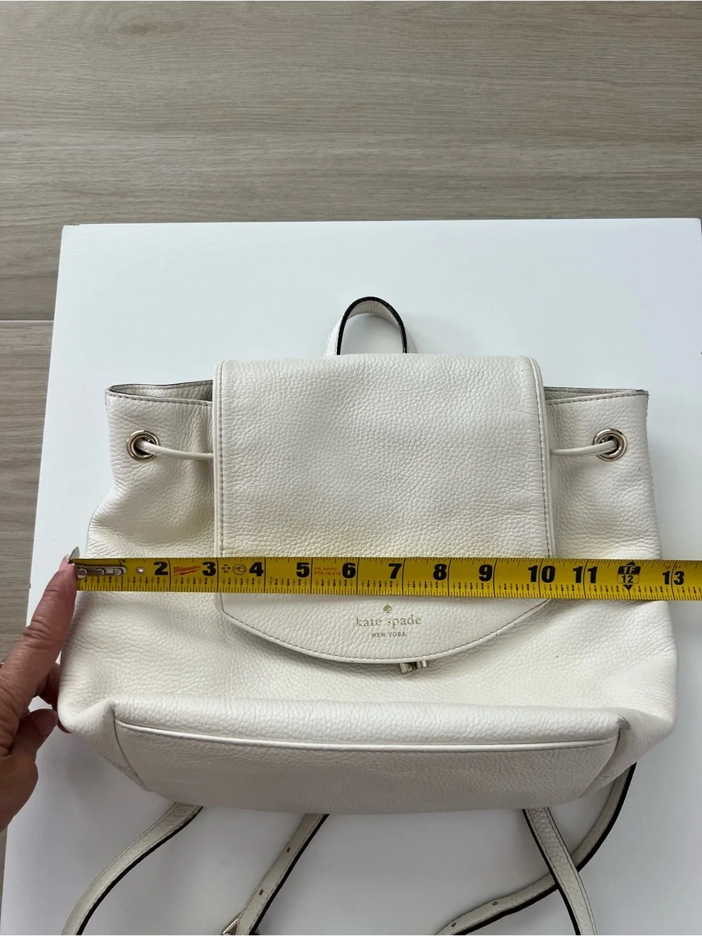 Kate Spade New York creamy white leather drawstring flap backpack